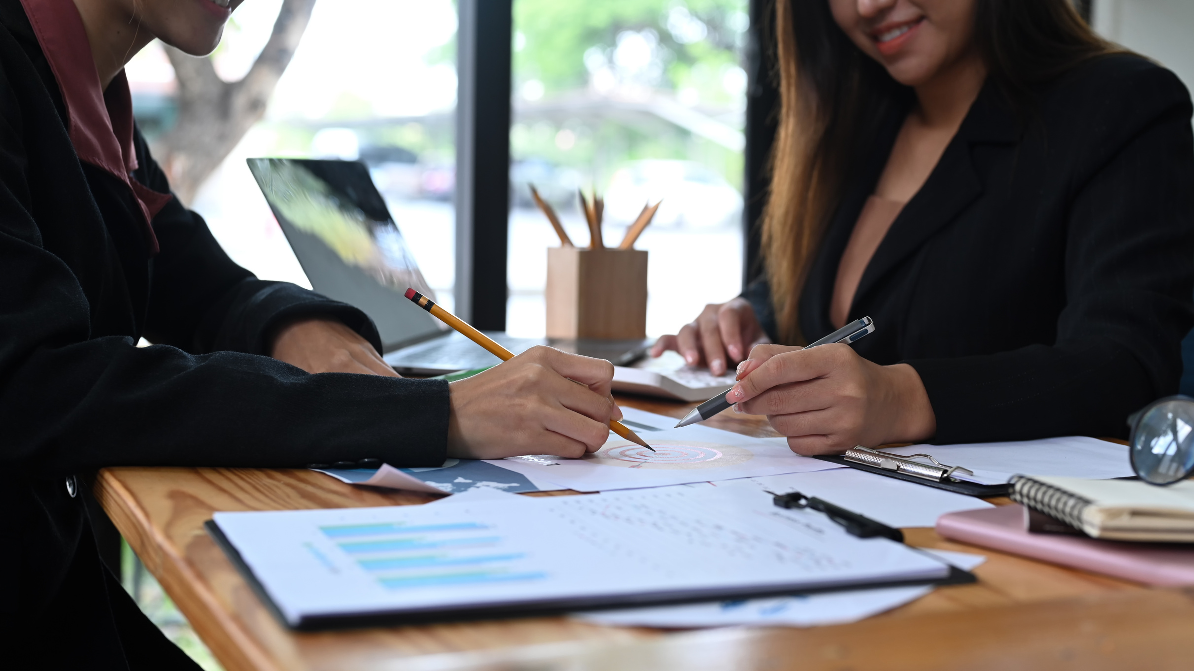 Cropped shot two business colleagues analyzing financial gra